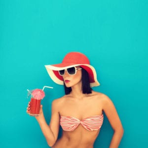 Woman in swimwear holding a glass of juice