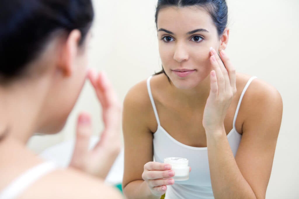 Woman applying skin care to her face