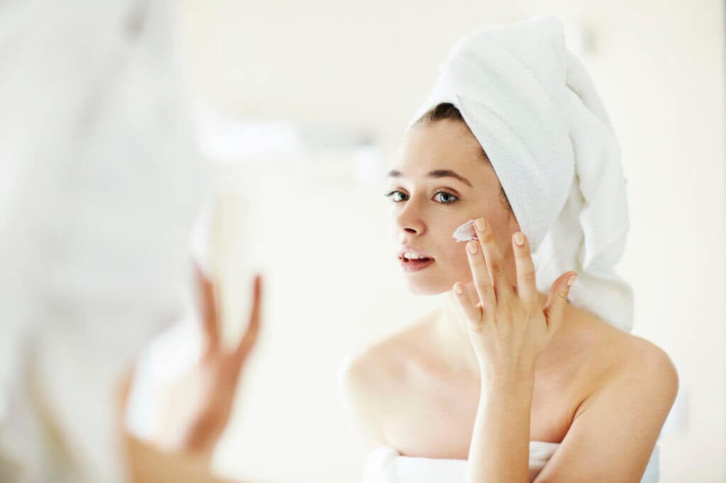 Woman applying skin care to her face