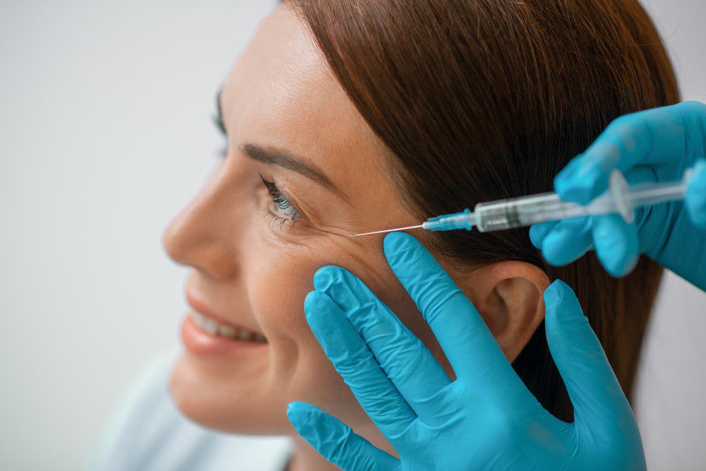 A woman receiving Botox injections to help smooth wrinkles around eyes.