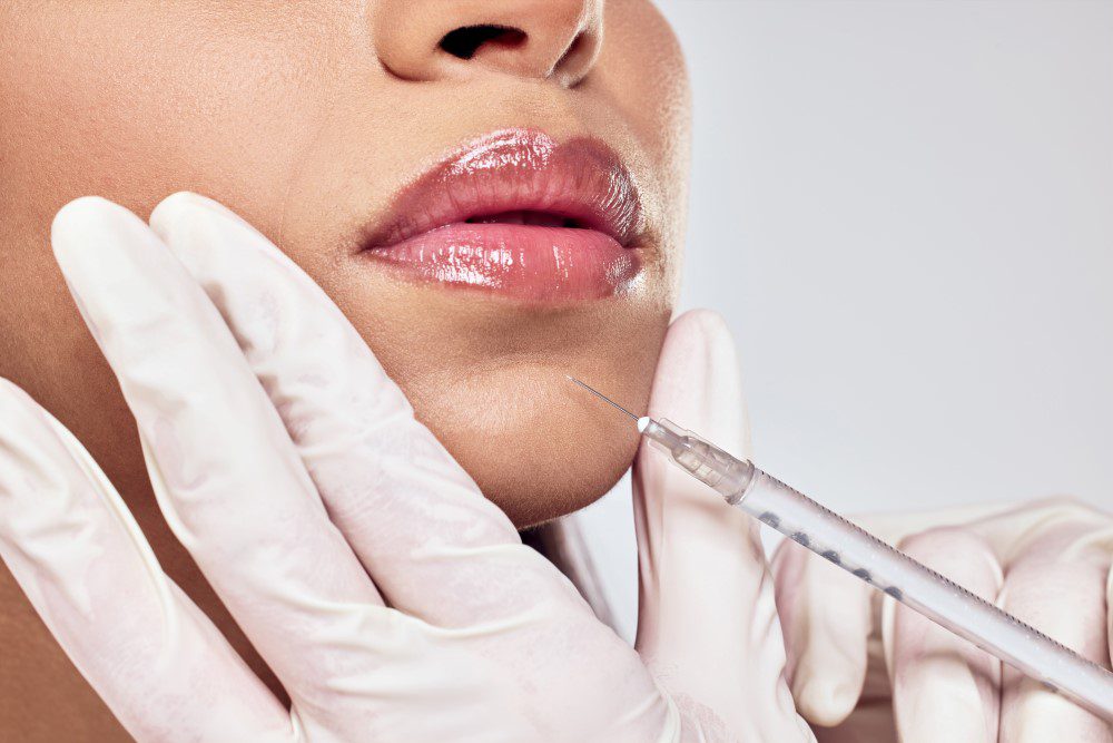 A woman receiving Botox injections in her chin by a Botox specialist.