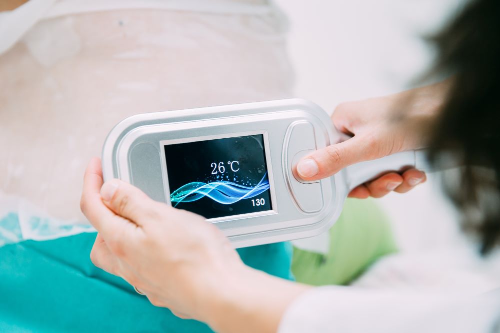 A practitioner holding up a CoolSculpting device to view how cold the device settings are.
