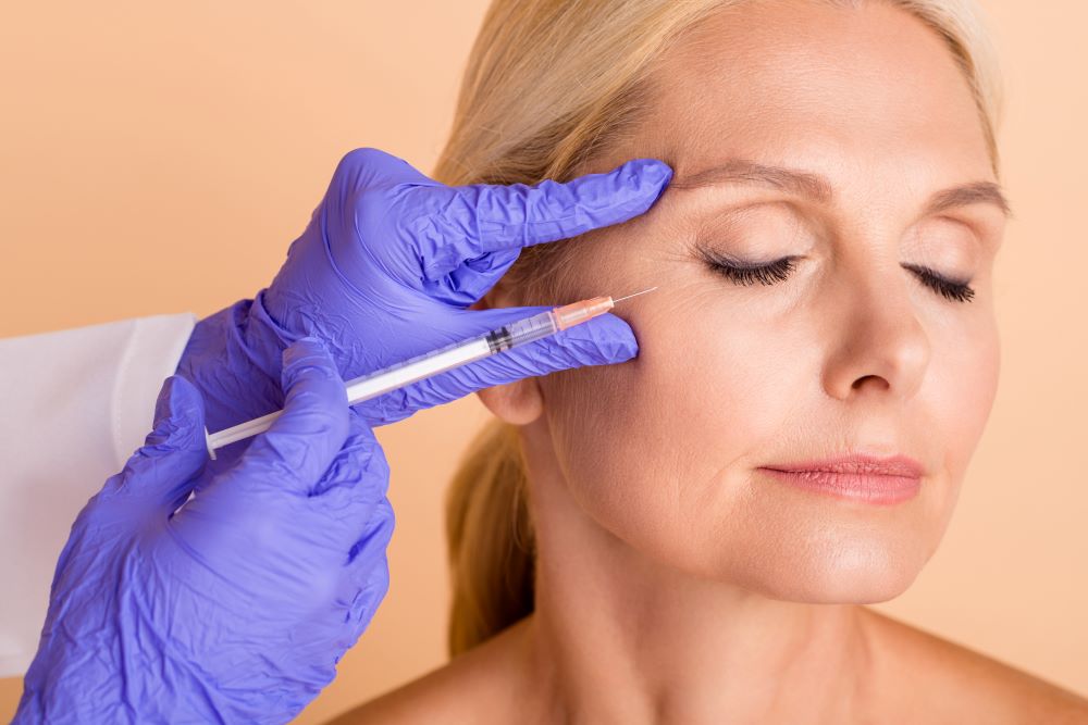 An older woman receiving Botox injections in for wrinkles around the eyes.