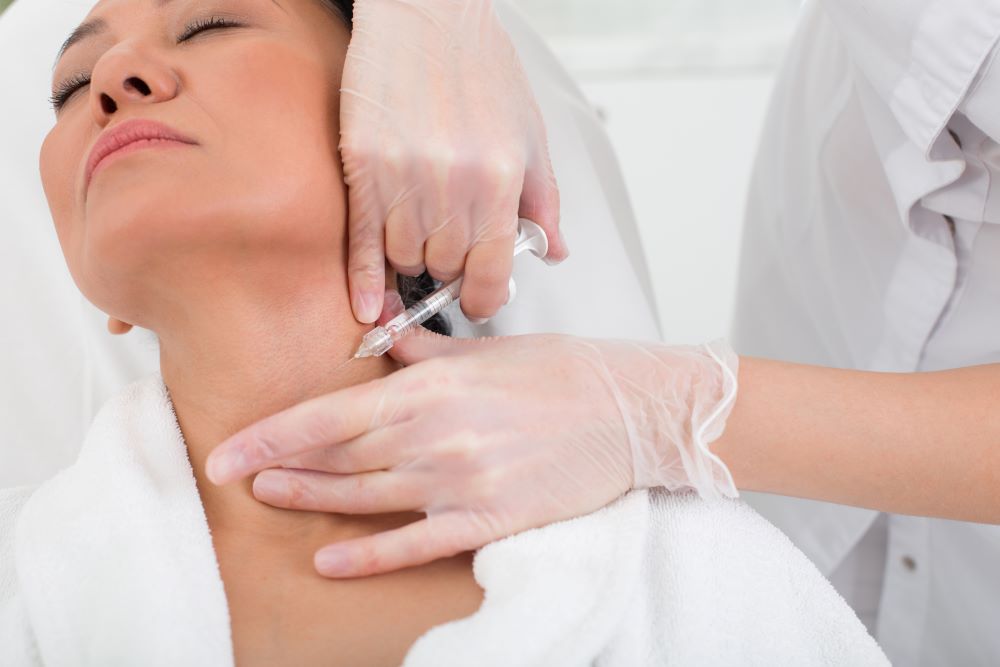 A woman receiving Botox in her neck at a medical spa.