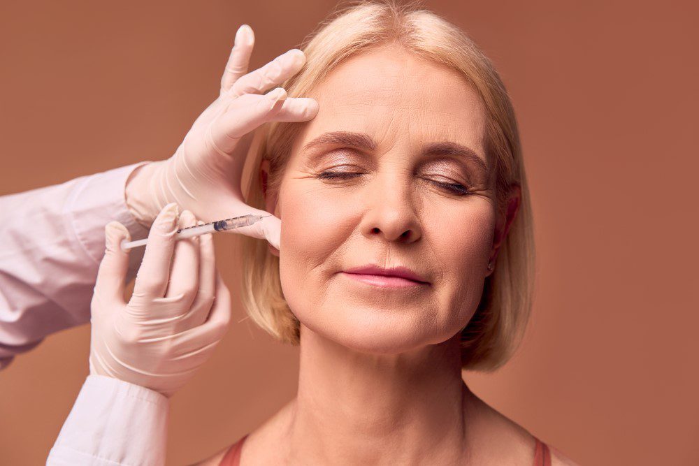 A woman receiving Botox injections on her cheeks.